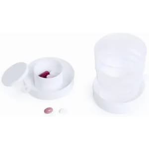 A medication organiser with multiple compartments, featuring a white exterior and two pills beside it.