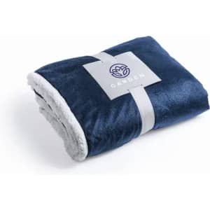 A navy blue blanket with a plush texture, featuring a grey underside and a logo on a tag.