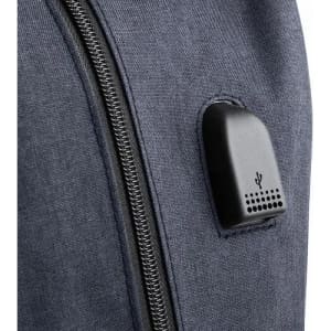 A close-up of a dark blue fabric surface featuring a black attachment with perforations and a logo.