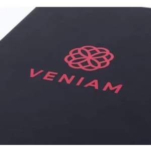 A black notebook with a red logo and the name "VENIAM" embossed on the cover.