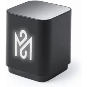 A compact black speaker with a silver top, featuring a logo on the front and a soft glow.