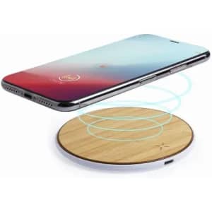 A wireless charging pad with a wooden surface and a smartphone hovering above it, emitting charging waves.