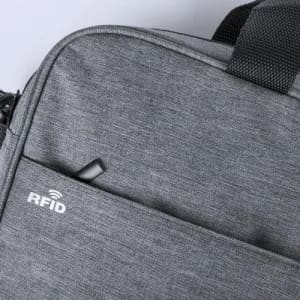 A grey RFID-protected bag with a textured fabric finish and a secure zip closure.