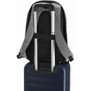 A grey backpack with adjustable straps being secured over the handle of a navy suitcase. The backpack features a branding logo.