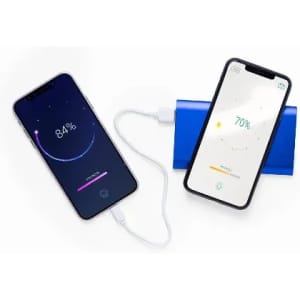 Two smartphones connected to a power bank, displaying battery charge percentages of 84% and 70%. The power bank is blue.
