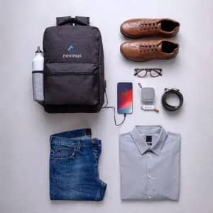 A drink bottle, grey backpack, brown shoes, jeans, a shirt, phone, glasses, watch, and a belt arranged neatly.