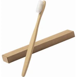 A bamboo toothbrush with soft bristles, resting beside a simple cardboard packaging. Eco-friendly design.