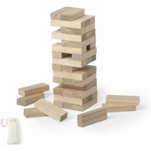 A wooden stacking game with rectangular blocks stacked in a tower and loose blocks surrounding it, along with a storage bag.