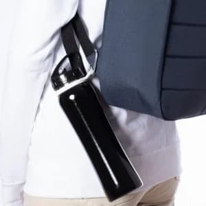 A drink bottle in black, attached to the side of a grey backpack. The bottle features a branded logo.