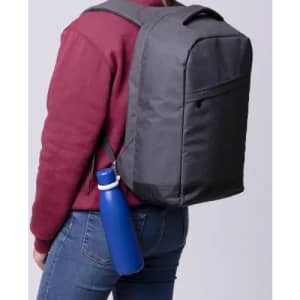 A drink bottle in vibrant blue secured to the side of a grey backpack, worn by a person.