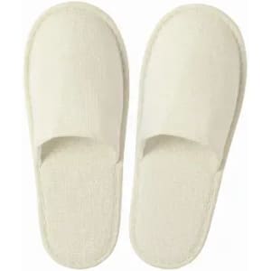 A pair of cream-coloured slippers with a simple, open-toe design. The slippers feature a textured surface.
