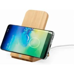 A wireless phone charger made of bamboo, holding a smartphone at an angle with a charging cable connected.