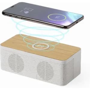 A wireless charging speaker with a wooden top and a white body, featuring sound output grills on the sides.