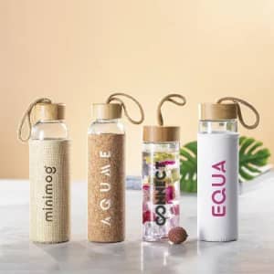 A collection of four drink bottles in natural materials, featuring a cork finish and a variety of designs.