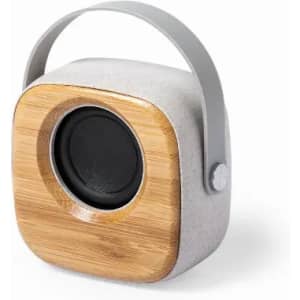 A compact speaker with a grey body and a bamboo front, featuring a handle for easy portability.