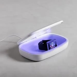 A white sanitising box with a purple interior, containing a black wristwatch.