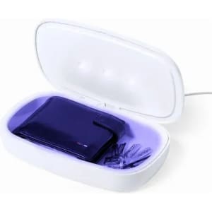 A white sanitising box with a purple interior, containing a wallet and several small items, is plugged in.