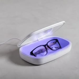 A glasses case with a white exterior and purple interior, containing a pair of black-framed glasses.