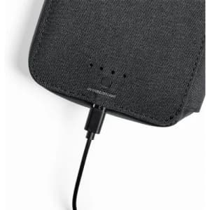 A black portable charger with a textured surface, showing charging connection and indicator lights.