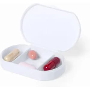 A pillbox containing four capsules of various shapes and colours, placed on a white background.