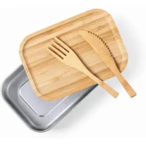 A wooden serving board sits on top of a silver tray, accompanied by a wooden fork and knife.