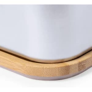 A drink bottle featuring a sleek white body with a bamboo base and rounded edges.