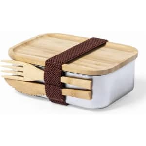 A lunch box with a wooden lid, featuring a brown strap and wooden utensils included.