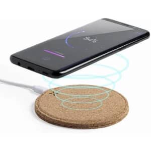 A wireless charging pad made of cork, with a smartphone displaying a charging icon.