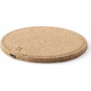 A round cork wireless charger in a natural beige colour, featuring a USB port at the edge and a minimalist design.