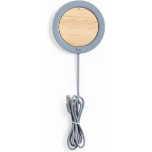 A wireless charger with a circular grey base and bamboo surface, featuring a grey charging cable.