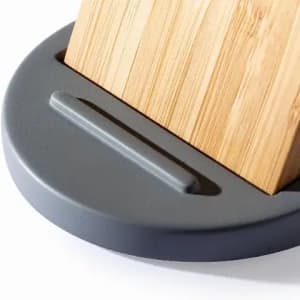 A bamboo block sits in a grey circular base, featuring a slotted design for stability.
