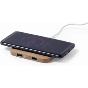 A wireless charger with a cork base, featuring two USB ports and a smartphone charging on top.