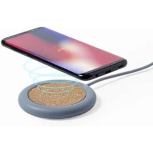 A wireless phone charger with a grey base and cork surface, charging a smartphone above it.
