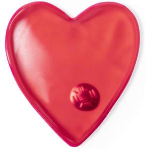 A heart-shaped heat pack in red, featuring a metal disc for activation.