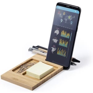 A bamboo organiser containing sticky notes, paper clips, and pens, with a smartphone displaying data graphs.