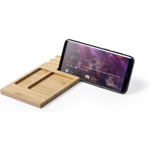 A bamboo organiser with two slots, holding a smartphone displaying a video.