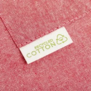 A close-up of a pink fabric showing a tag that reads "Recycled Cotton" with a recycling symbol.