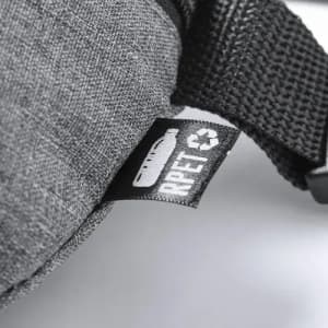 A close-up of a grey textured material with a tag featuring a logo and recycling symbol.