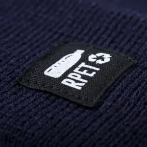A drink bottle with a textured navy blue surface, featuring a black patch with a logo.
