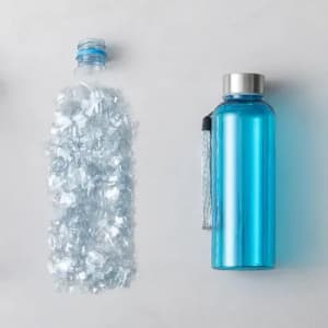 A blue drink bottle with a silver cap next to a bottle filled with clear plastic shards.