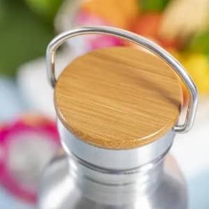 A drink bottle with a silver body and a wooden bamboo lid, featuring a metal handle.