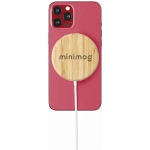 A phone with a pink case and a bamboo wireless charger attached, featuring a logo on the charger.