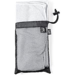 A towel packed in a black mesh bag with a drawstring closure. The towel is white, and the bag features a logo.