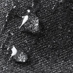 A close-up of water droplets on a textured black fabric surface.