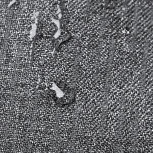 A textured grey fabric with water droplets on the surface, showcasing its water-resistant properties.