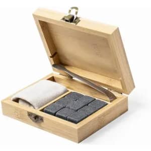 A bamboo box containing six grey whisky stones, a pair of tongs, and a grey cloth. The box has a clasp closure.