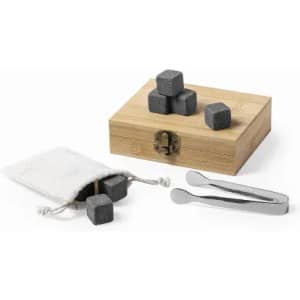 A wooden gift box containing grey whisky stones, a pouch with additional stones, and metal tongs.