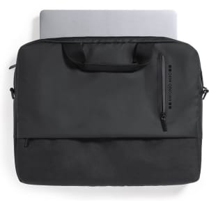 A black laptop bag with a zippered pocket, featuring dual handles and a sleek design. A laptop is visible inside.