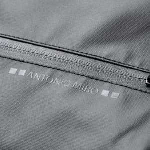 A grey fabric with a zippered pocket featuring a logo. The texture appears smooth and durable.