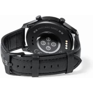 A black watch featuring a leather strap and a circular watch face with sensors on the back.